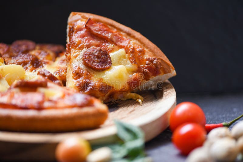 Fetta della pizza sulla foglia di legno del basilico dei peperoncini rossi del pomodoro e del vassoio formaggio tradizionale ital immagini stock Fetta della pizza sulla foglia di legno del basilico dei peperoncini rossi del pomodoro e del vassoio formaggio tradizionale ital immagini stock