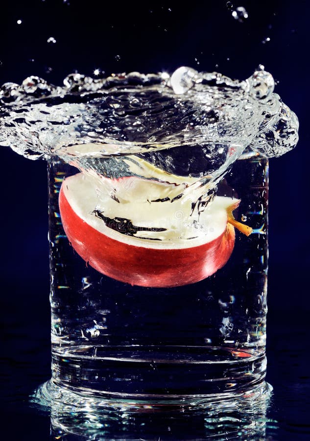 Fetta di mela rossa che cade in acqua immagine stock Fetta di mela rossa che cade in acqua immagine stock