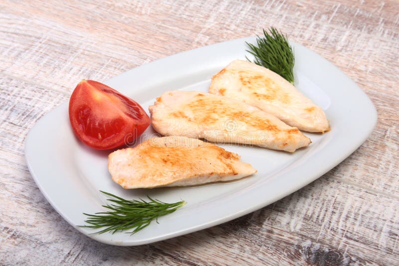 Fette di petto di pollo e di pomodoro arrostiti sul piatto bianco fotografia stock libera da diritti Fette di petto di pollo e di pomodoro arrostiti sul piatto bianco fotografia stock libera da diritti