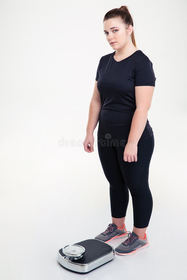 Fette Frau, die mit Waage steht lizenzfreies stockfoto Fette Frau, die mit Waage steht lizenzfreies stockfoto
