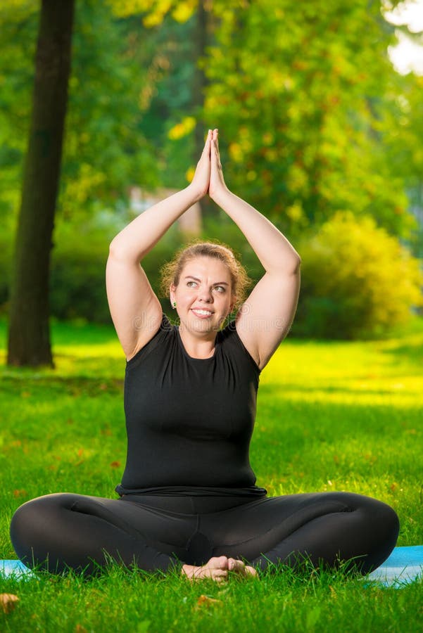 fette Frau, die Yoga im Park im Lotos tut stockbilder fette Frau, die Yoga im Park im Lotos tut stockbilder