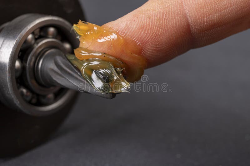Grease lubrication of the bearing and the pin of the electric rotor. Service work of engine parts. Dark background. Grease lubrication of the bearing and the pin of the electric rotor. Service work of engine parts. Dark background