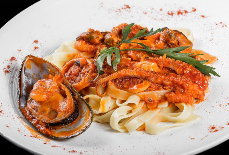 Fettuccinedeegwaren met zeevruchten, mosselen, octopus, oesters, tomatensaus en kruiden royalty-vrije stock afbeeldingen Fettuccinedeegwaren met zeevruchten, mosselen, octopus, oesters, tomatensaus en kruiden royalty-vrije stock afbeeldingen