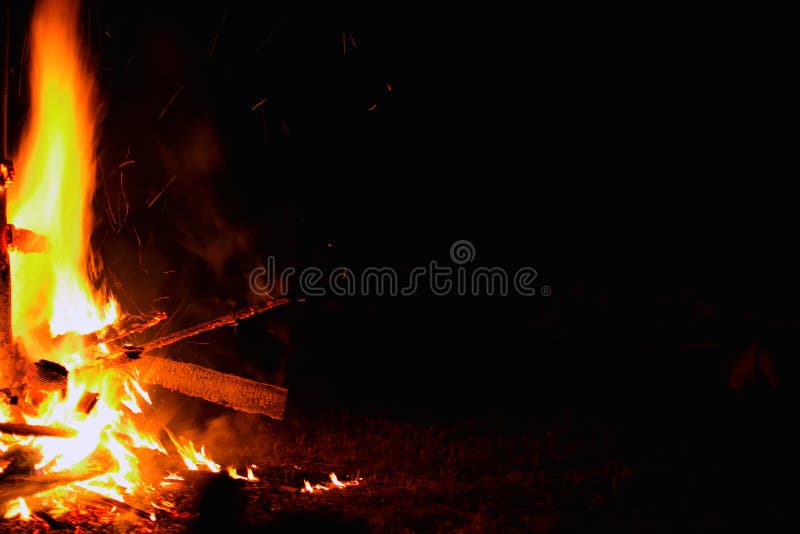 Bonfire on a dark background. Beautiful fire flames on black. Burning wood at night. Glowing big campfire at touristic camp. Copy space. Bonfire on a dark background. Beautiful fire flames on black. Burning wood at night. Glowing big campfire at touristic camp. Copy space.
