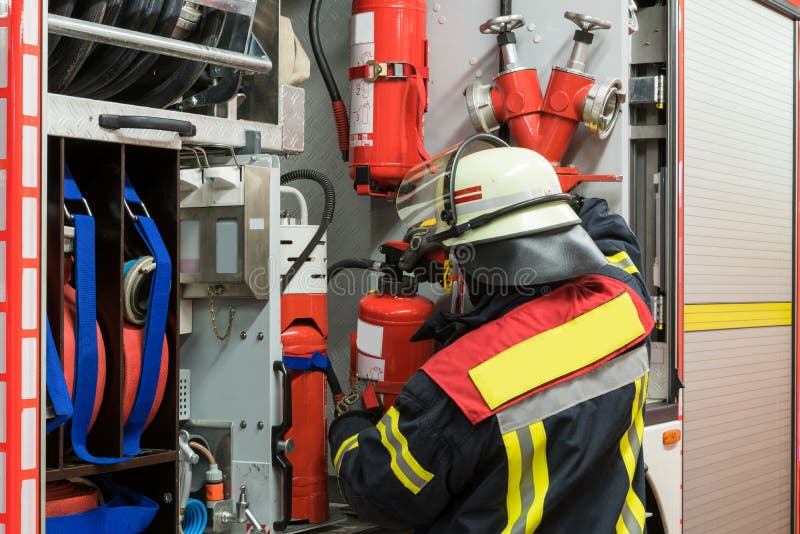 Feuerwehrmann mit einem Feuerlöscher auf dem Löschfahrzeug stockfotografie Feuerwehrmann mit einem Feuerlöscher auf dem Löschfahrzeug stockfotografie