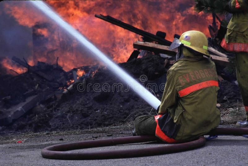 Feuerwehrmann mit Schlauch lizenzfreies stockfoto Feuerwehrmann mit Schlauch lizenzfreies stockfoto