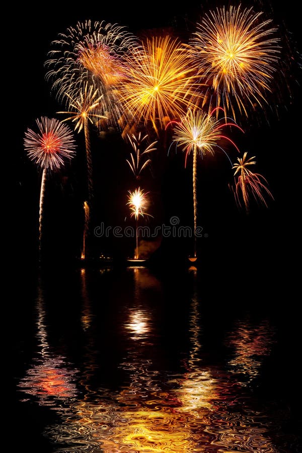 Feuerwerke auf nächtlichem Himmel mit Seereflexionen lizenzfreie stockbilder Feuerwerke auf nächtlichem Himmel mit Seereflexionen lizenzfreie stockbilder