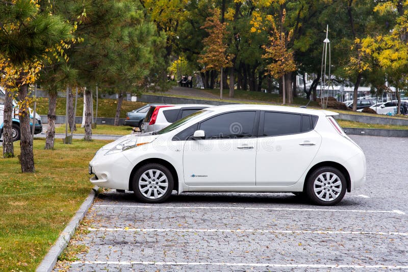Feuille blanche de Nissan garée dans le stationnement photographie stock Feuille blanche de Nissan garée dans le stationnement photographie stock