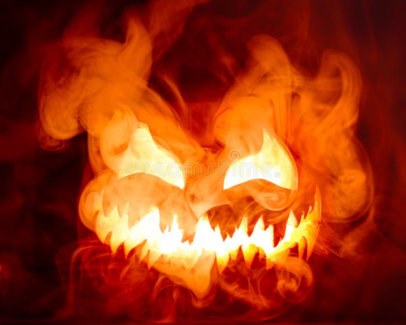 Feurig rotes heißes halloween jack o lantern Kürbis geschnitzt mit beängstigend böse Gesicht hell mit dicken Rauch stockfotos