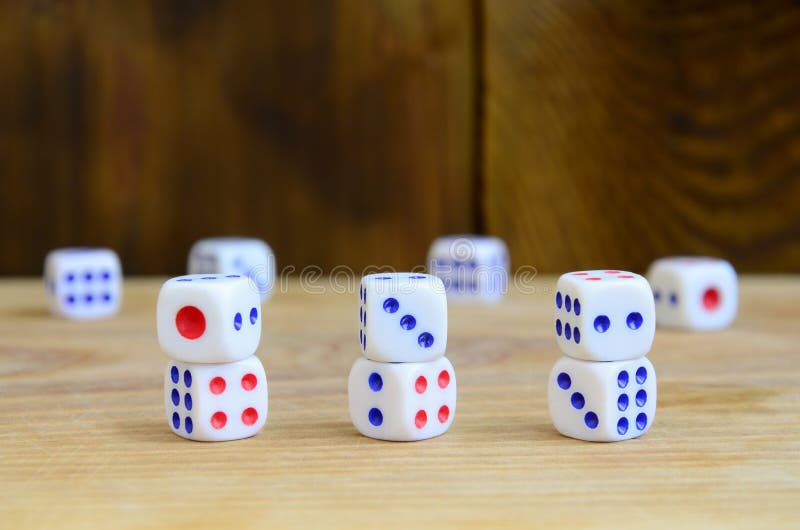 A few dice lies on the surface of natural wood. Items for generating numbers from one to six in the form of points that are paint