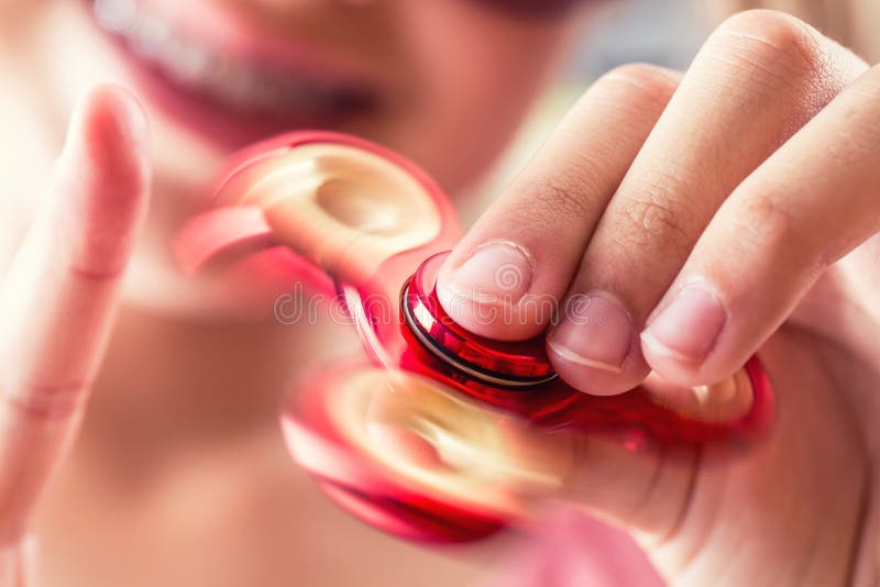 Fidget Spinner. Cute young girl playing with fidget spinner royalty free stock image
