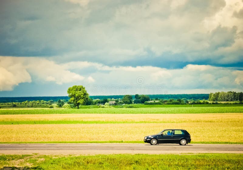 Field and car on a road