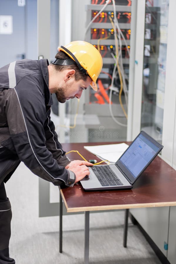 Field service engineer inspect relay protection system with laptop comput royalty free stock image