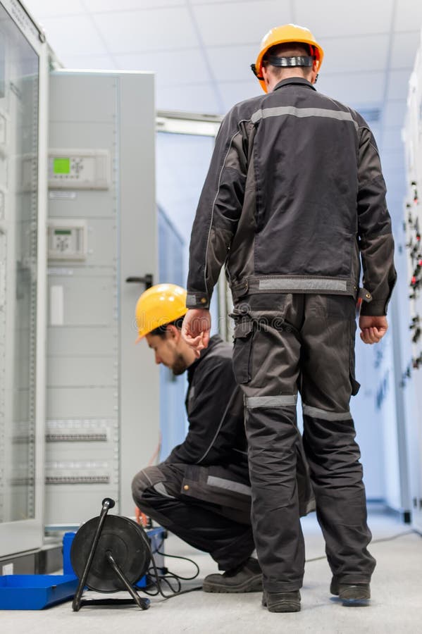 Field service engineers inspect system with relay test set equip stock image