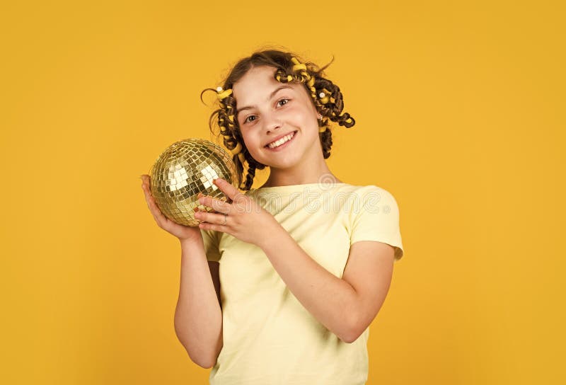 Fiesta retro. niña alegre con bola de disco. un chico de moda posando con rizos en el pelo. jocoso. peinado para discoteca fotos de archivo libres de regalías
