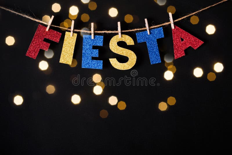 Fiesta word made of shiny paper and pins on black background and bokeh lights. Cinco de mayo concept.