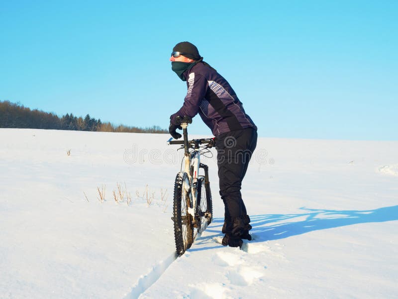 Fiets van de fietser de duwende berg op sneeuwafwijking Weer van de vorst het zonnige winter De fietser duwt fiets in diepe sneeu royalty-vrije stock foto's Fiets van de fietser de duwende berg op sneeuwafwijking Weer van de vorst het zonnige winter De fietser duwt fiets in diepe sneeu royalty-vrije stock foto's