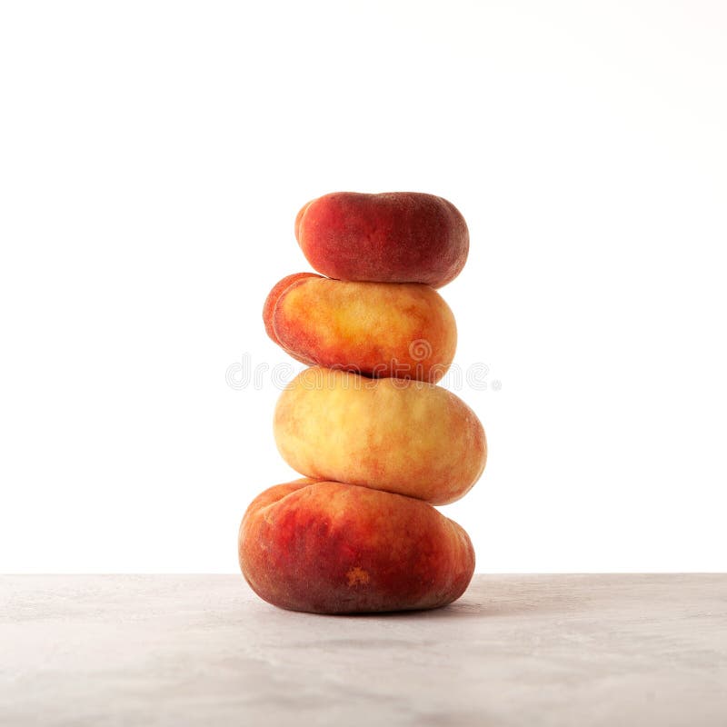 Fig peaches stack. Flat donut peaches balanced on the table stock image