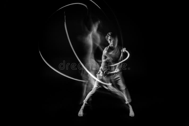 Fighter in the dark with lightsaber. long exposure. Emotional male portrait. royalty free stock photo Fighter in the dark with lightsaber. long exposure. Emotional male portrait. royalty free stock photo