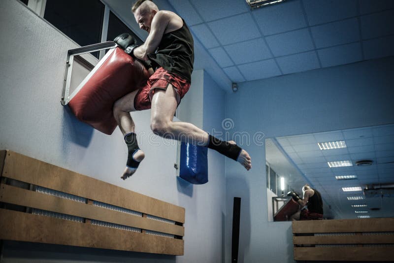 Fighter Training With Punching Pad At Gym