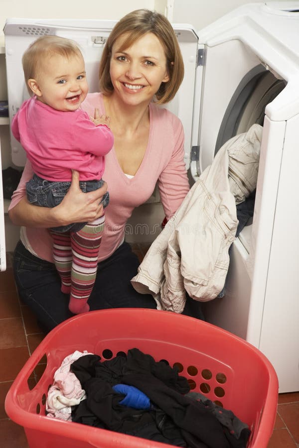 figlia che fa la donna della lavanderia della holding fotografie stock libere da diritti figlia che fa la donna della lavanderia della holding fotografie stock libere da diritti