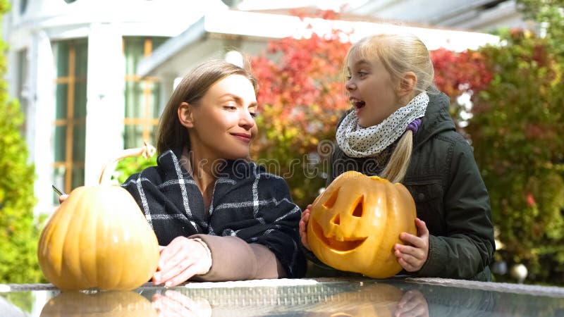Figlia che porta la presa-o-lanterna della zucca per generare, preparazione per Halloween immagine stock Figlia che porta la presa-o-lanterna della zucca per generare, preparazione per Halloween immagine stock