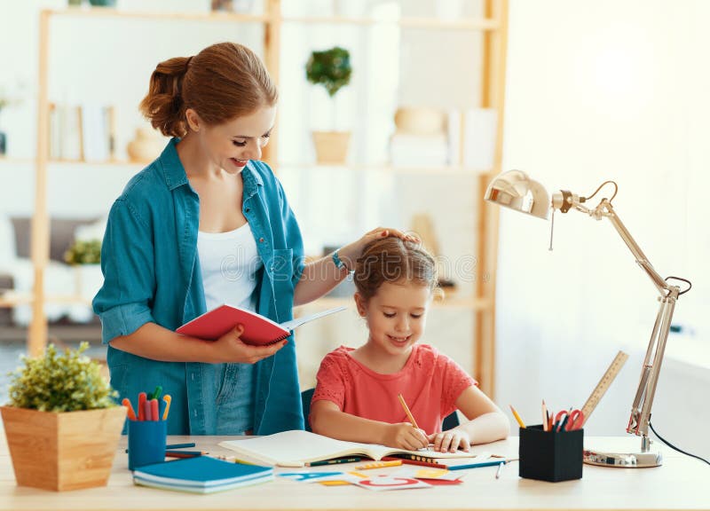 Figlia del bambino e della madre che fa scrittura e lettura di compito fotografie stock libere da diritti Figlia del bambino e della madre che fa scrittura e lettura di compito fotografie stock libere da diritti
