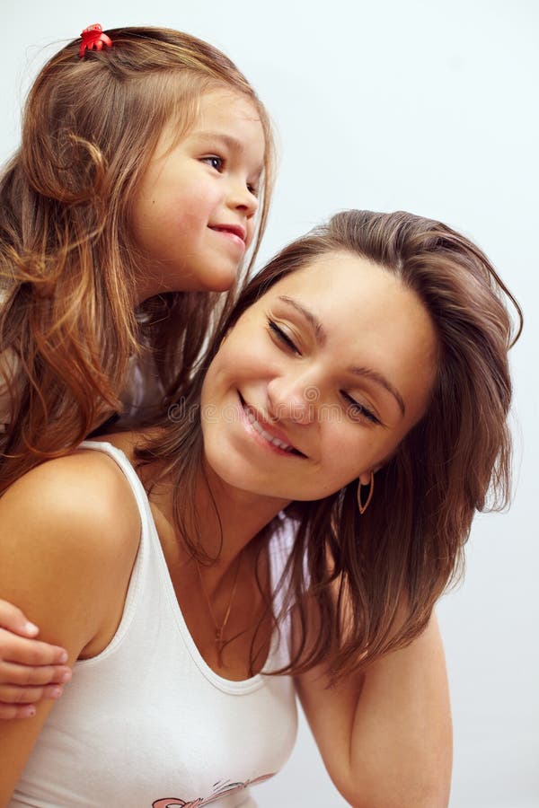 Figlia sorridente felice che abbraccia bella madre fotografia stock Figlia sorridente felice che abbraccia bella madre fotografia stock