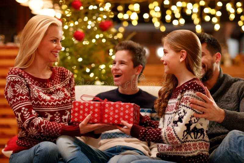 Figlia sveglia che dà il regalo di Natale alla madre fotografie stock Figlia sveglia che dà il regalo di Natale alla madre fotografie stock