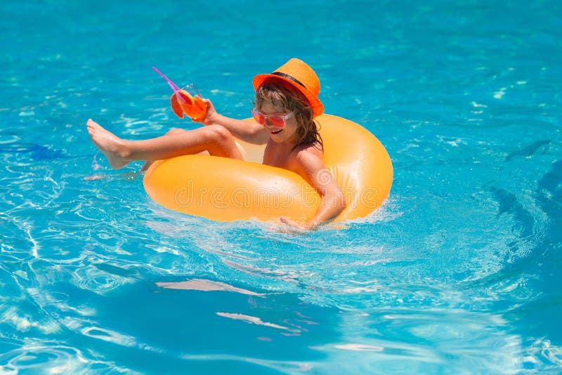 Figlio che galleggia nel pool. bambini rilassati in piscina bevono cocktail estivo. ragazzino galleggiante in piscina immagine stock