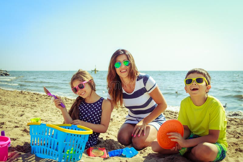 Figlio della figlia della madre della famiglia divertendosi sulla spiaggia immagine stock libera da diritti Figlio della figlia della madre della famiglia divertendosi sulla spiaggia immagine stock libera da diritti