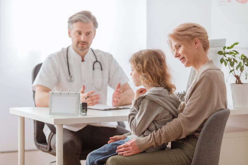 Figlio malato di fronte alla bella scrivania di pediatria fotografia stock libera da diritti