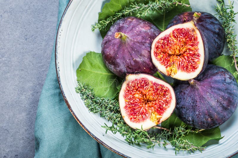 Figos roxos frescos num prato fotografia de stock royalty free