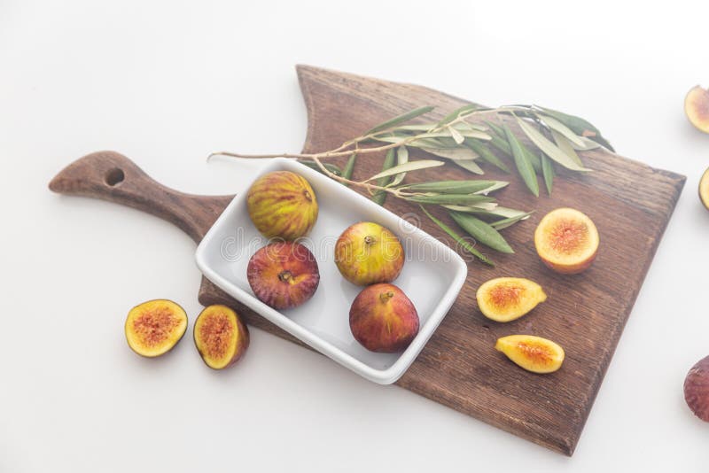 Figs Whole and Halves in White Rectangular Porcelain Plate on a Cutting