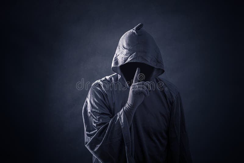 Scary figure in hooded cloak in the darkness. Scary figure in hooded cloak in the darkness