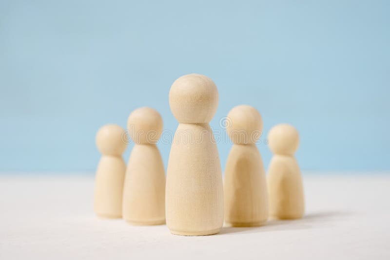 Figuras abstractas de juguetes de madera del jefe en el centro y subordinados detrás de él imagenes de archivo