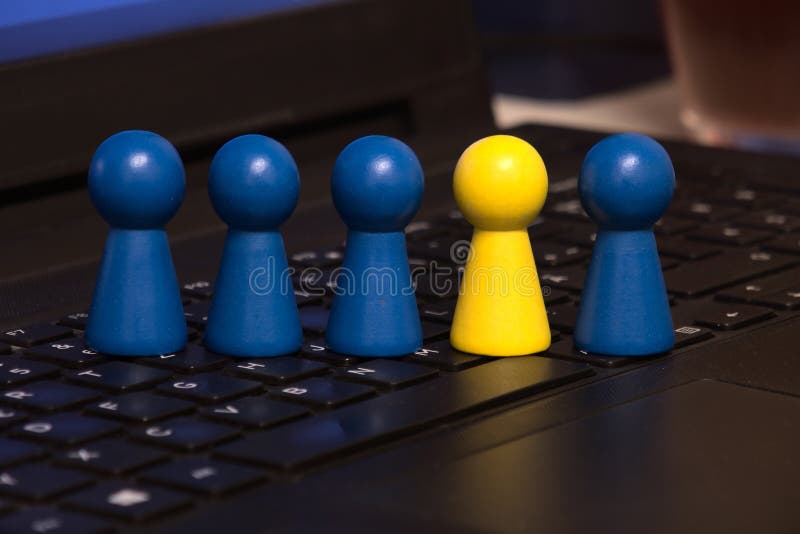 Toy figures in a row on a keyboard with one highlighted one. Toy figures in a row on a keyboard with one highlighted one