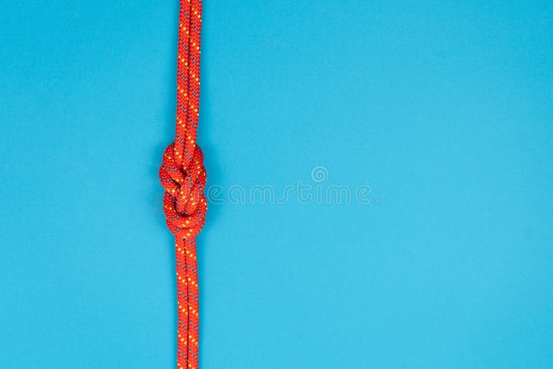 Figureeight Knot with Red Climbing Rope on Blue Background Stock Photo