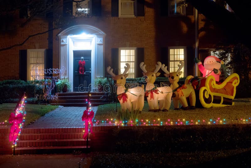Figure gonfiabili: Santa Claus in una slitta con i cervi vicino alla h immagine stock libera da diritti