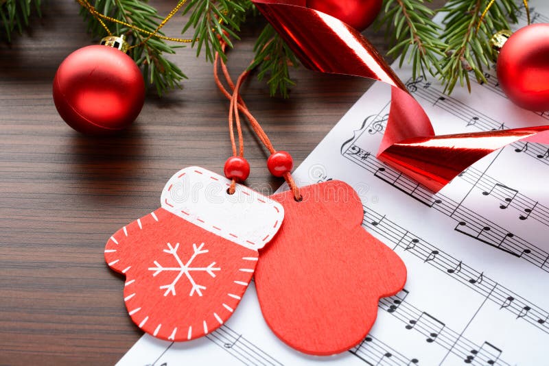 Figure mittens and balls fir branch on a wooden background