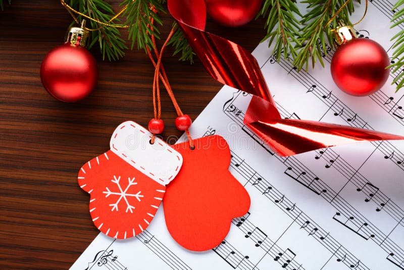 Figure mittens and balls fir branch on a wooden background