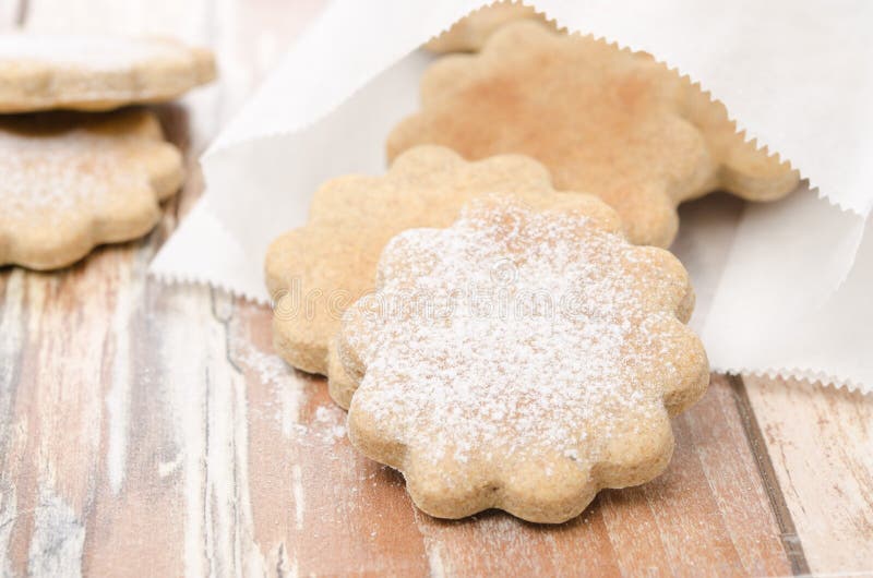 Figured cookies sprinkled with powdered sugar in a paper bag stock photo