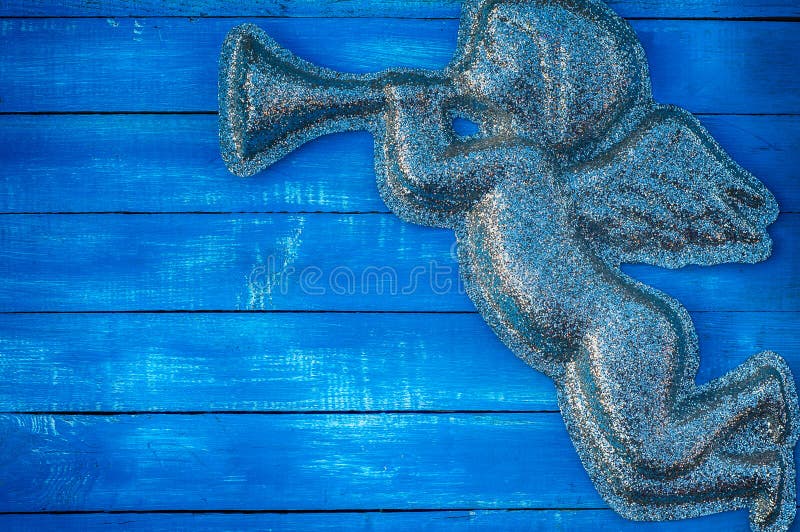 Figurera ängeln av skinande partiklar på en blå träbakgrund arkivbild Figurera ängeln av skinande partiklar på en blå träbakgrund arkivbild