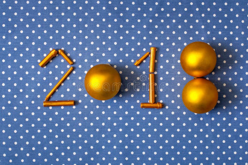 Figures New Year 2018 golden christmas balls and gilt sticks on a cloth background in polka dots royalty free stock photos Figures New Year 2018 golden christmas balls and gilt sticks on a cloth background in polka dots royalty free stock photos