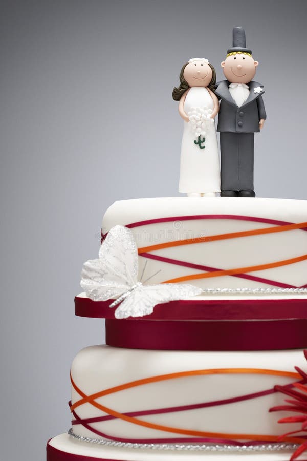 Comical bride and groom figurines on top of wedding cake. Comical bride and groom figurines on top of wedding cake