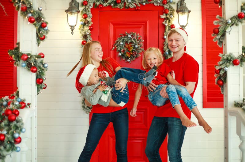 Fijne familie in Kerstmis in de tuin van het huis van Nieuwjaar, traditie die ouders met kinderen vierde royalty-vrije stock afbeelding Fijne familie in Kerstmis in de tuin van het huis van Nieuwjaar, traditie die ouders met kinderen vierde royalty-vrije stock afbeelding