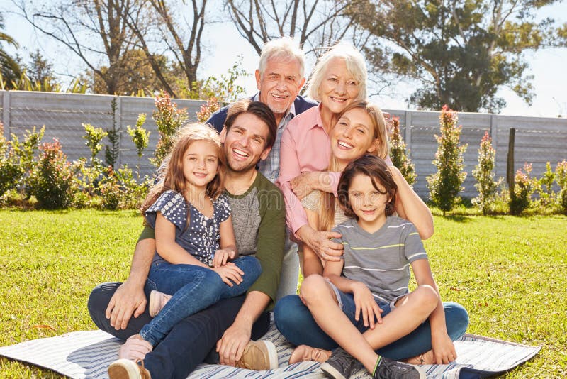 Fijne familie met drie generaties in de tuin royalty-vrije stock foto Fijne familie met drie generaties in de tuin royalty-vrije stock foto