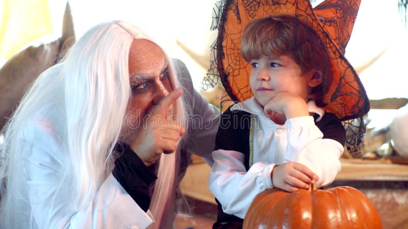 Fijne grootvader en kindjongen in Halloween Costume Scenario-verhalen Mannen en jongen schrikken gasten Halloween thuis