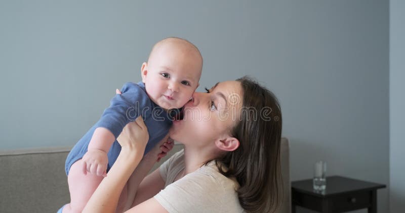 Fijne lachende moeder en baby, zuigeling in armen van jonge mooie moeder