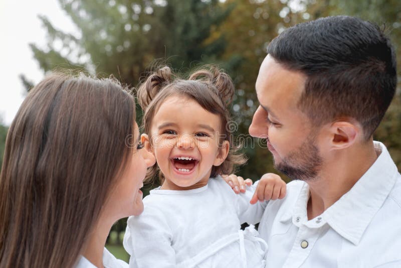 Fijne meid die met haar ouders in het park lachte stock foto's Fijne meid die met haar ouders in het park lachte stock foto's
